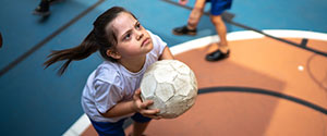 Focused child with disability playing basketball